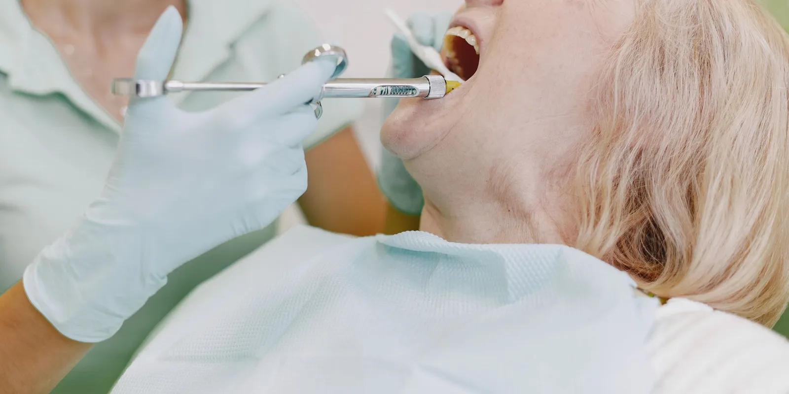 A patient sitting calmly in a dental chair while a dentist explains the treatment